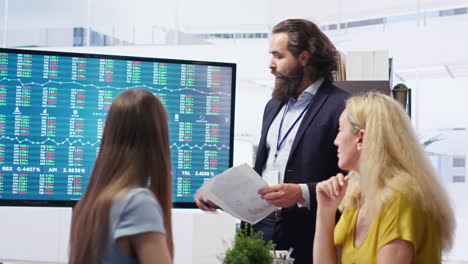 hombre de negocios mostrando aumento de la demanda de acciones en una gran exhibición