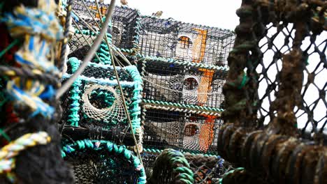 stacked empty fishing industry lobster bait net baskets closeup dolly right