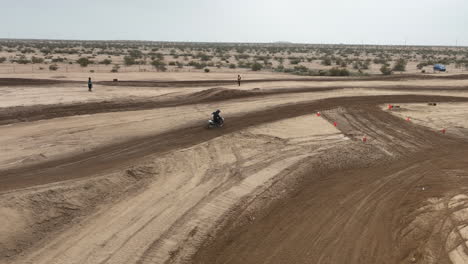 carreras de motos en una pista todoterreno y rampas de tierra saltando - vista aérea en cámara lenta