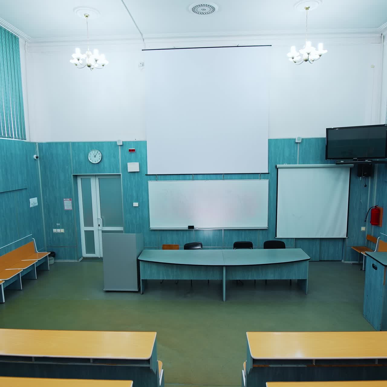 Empty lecture hall in the university. Beautiful classroom in the educational centre with modern interior. Conference hall with blackboard and modern equipment. Panoramic view