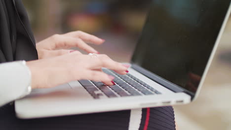 Primer-Plano-De-Una-Mujer-Escribiendo-En-El-Teclado-Mientras-Trabaja-Afuera,-En-Cámara-Lenta