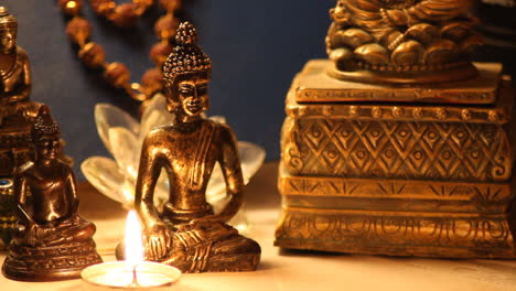 buddha statue meditating with candle burning close up 15