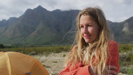 caucasian woman having a good time on a trip to the mountains, looking away and smiling