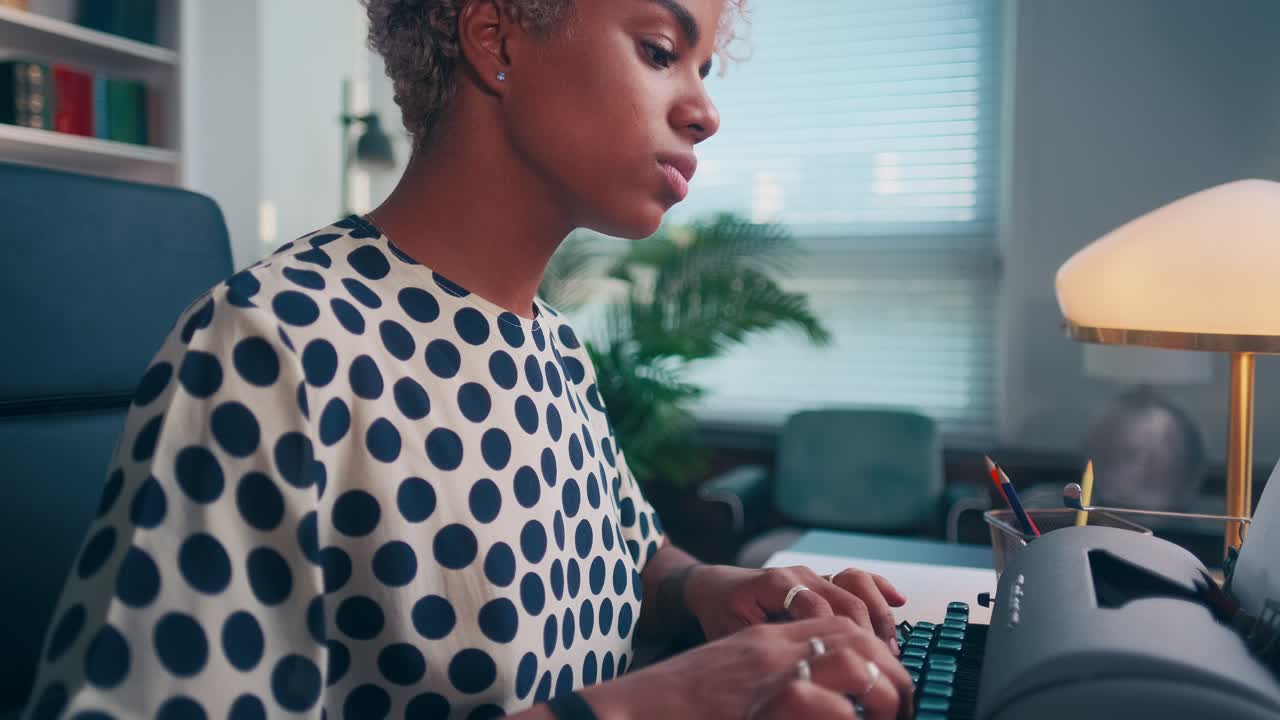 Focused dark skin female author using old typewriter creates interesting story