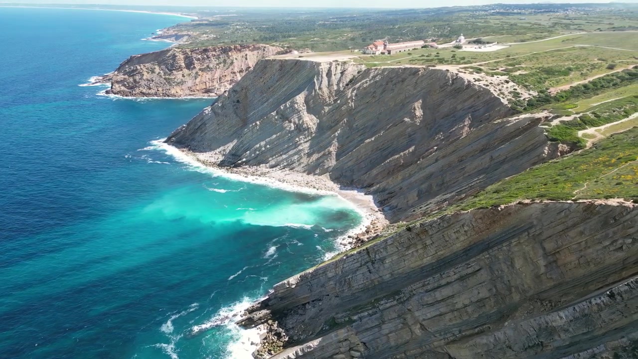 Dronebeelden vanuit de lucht van Cabo Espichel, Portugal: dramatische Atlantische kliffen, ruige kustlijn en uitgestrekt oceaanlandschap onder natuurlijk licht. Ideaal voor reis- en natuurprojecten.