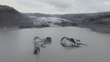 Aerial-drone-view-over-ice-blocks,-towards-the-Solheimajokull-Glacier,-in-Iceland