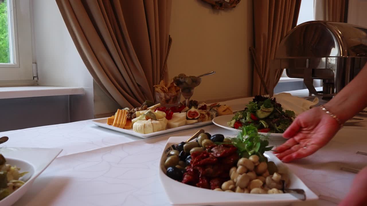 Professional chef arranges gourmet dishes on table during restaurant service prep