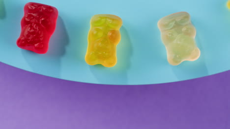 colorful gummy bears on a blue and purple background