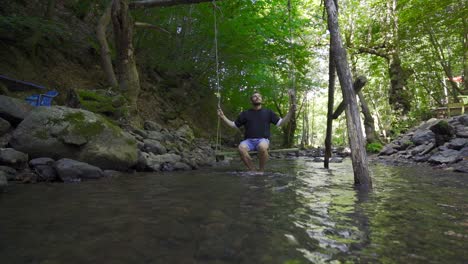 swinging on a swing at the creek in slow motion.