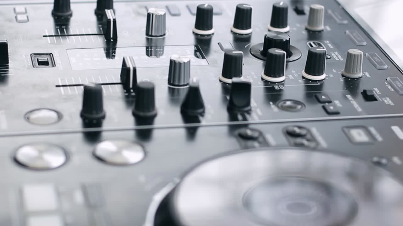 Close up shot DJ hand live perform; play and mixing music move slidder fadder and switch the knob on dj mixer equipment controller; DJ daytime party