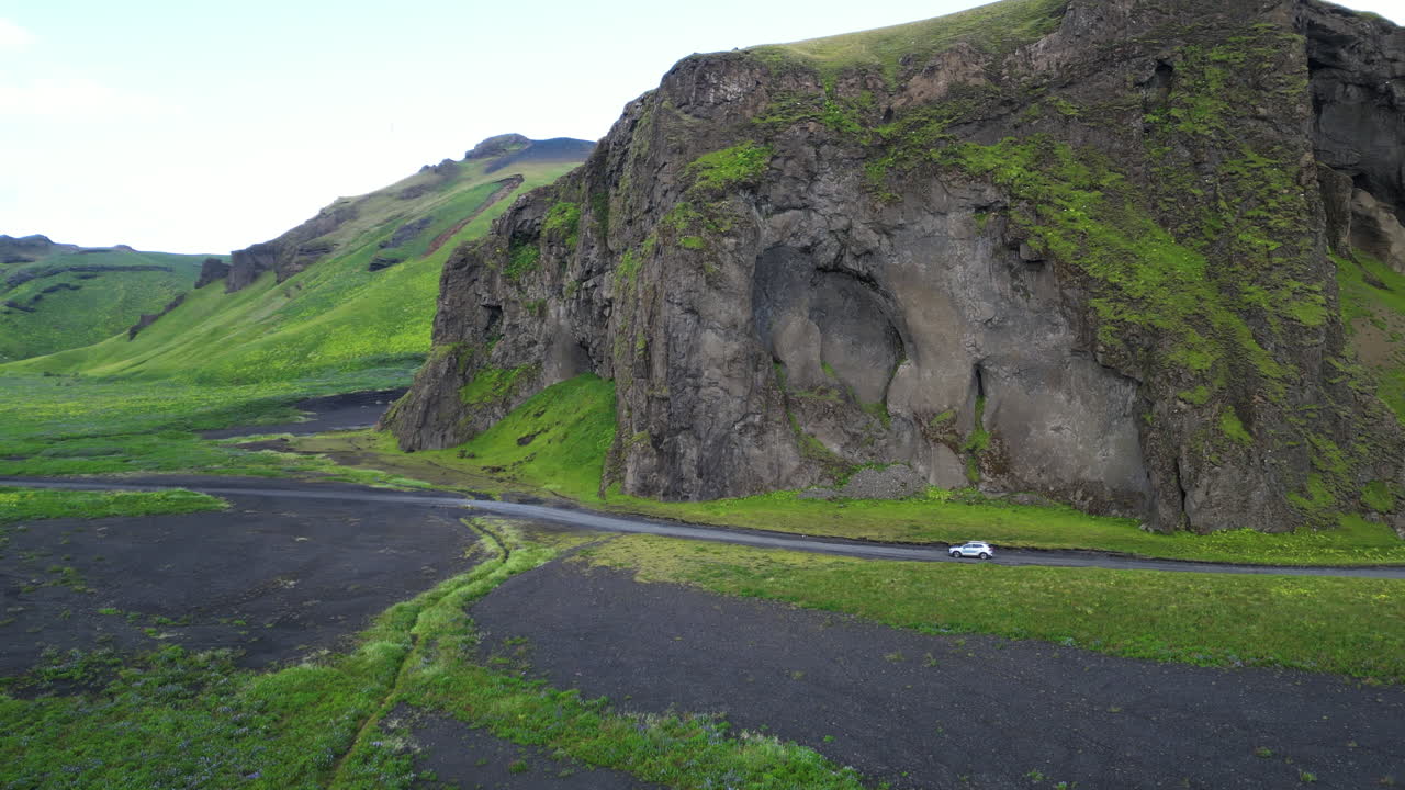 Cars Driving Along Hjorleifshofdi Tuya Cliff In Southern Iceland. - aerial tracking shot