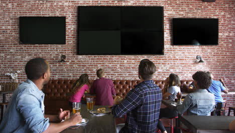 amigos viendo el juego en el bar de deportes en pantallas filmadas en r3d