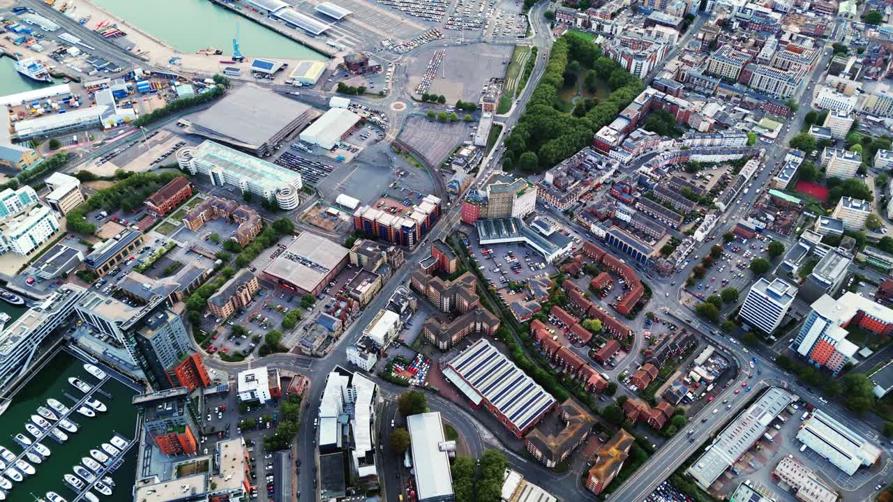 High-angle aerial drone view over Southampton city near the sea at Ocean Village, showcasing boats, marina, and surrounding trees under clear light for a scenic urban coastal landscape