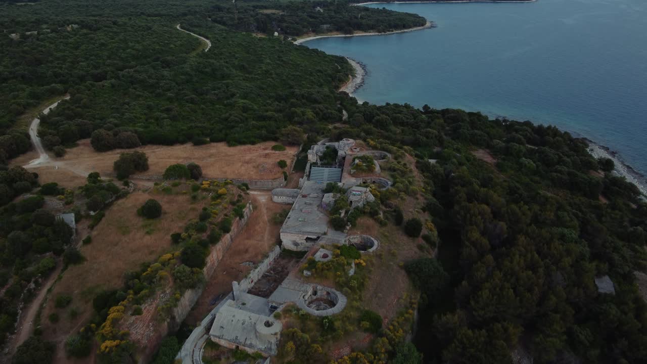 drone de vista aérea cinematográfica sobre una fortificación histórica de la primera guerra mundial junto al mar junto al idílico mar mediterráneo adriático con agua azul y playas escondidas para viajar en verano