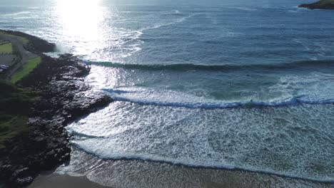 Drone-aerial-rocky-headland-coastline-scenery-ocean-waves-surfers-early-morning-sunrise-swell-white-wash-sand-bar-travel-tourism-Gerringong-Kiama-blow-hole-NSW-South-Coast-Australia-4K