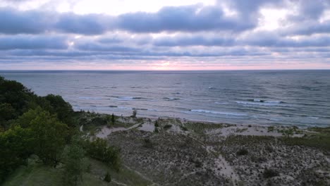 ecosistema de dunas de sobrevuelo aéreo y lago de michigan grandes lagos al atardecer