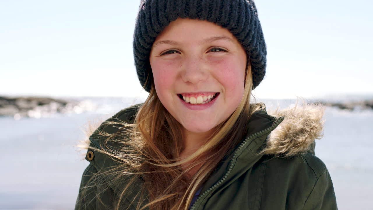 Criança, sorriso e retrato de praia no inverno