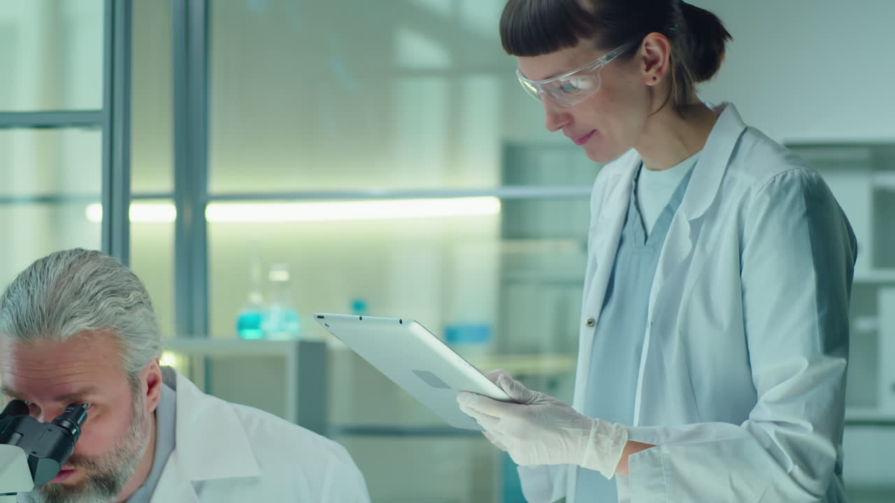 Senior Scientist Doing Lab Experiment with Female Assistant