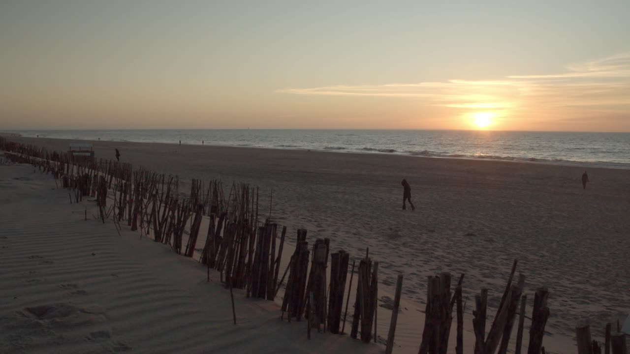 plano general de la puesta de sol en la playa de sylt con gente caminando