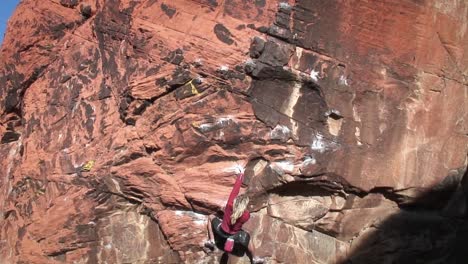 a climber ascends a rock face