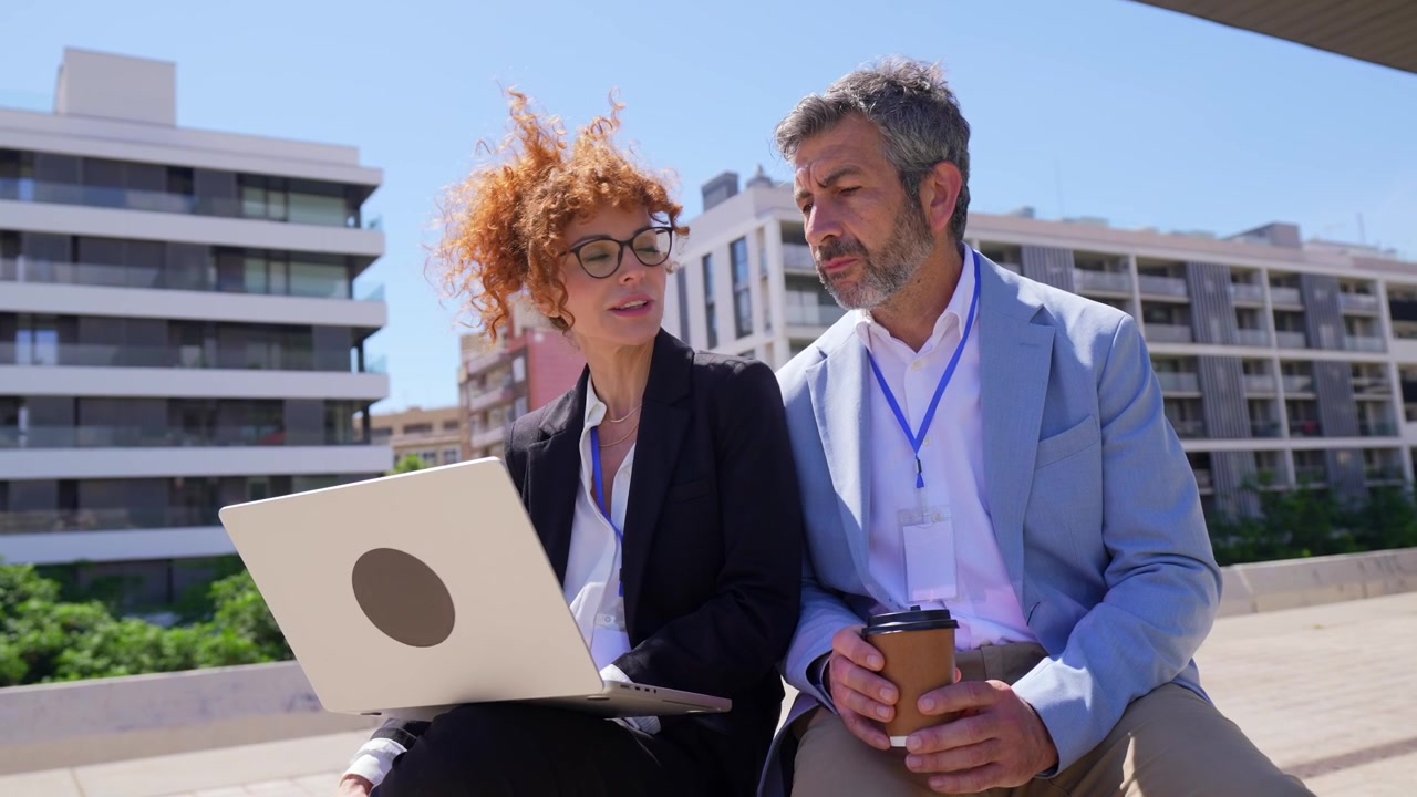 Professionele collega's werken samen op een laptop tijdens een buitenvergadering