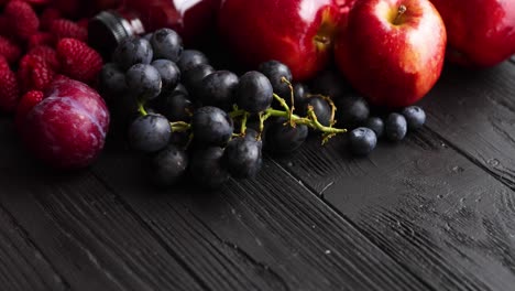 Various-fresh-red--purple-black-fruits--Mix-of-fruits-and-bottled-juices-on-black