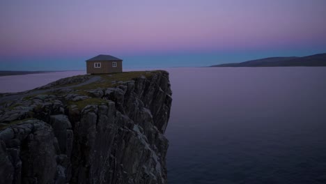 small house on a clifftop at sunset