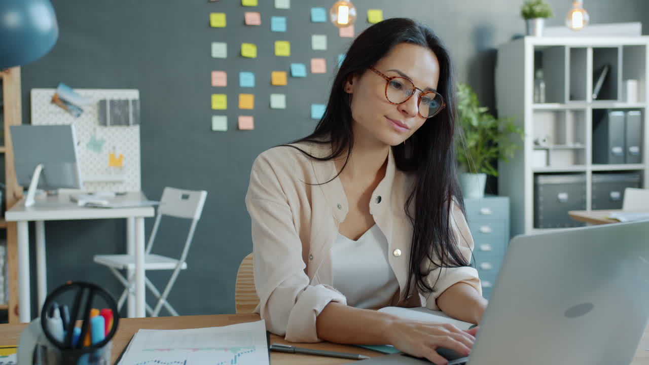 mujer trabajando en una computadora portátil en una oficina moderna