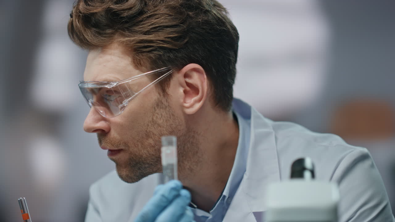 científico de primer plano examinando medicamentos en un laboratorio de bioquímica en un tubo de ensayo