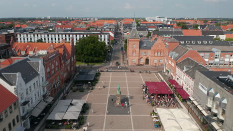 Flight-over-Torvet-square-in-Esbjerg,-Denmark-with-the-statue-of-Christian-IX-and-the-Kommune,-the-Town-Hall.-Top-down-aerial-view-of-Torvegade-pedestrians-street-and-scenic-panorama-of-the-city