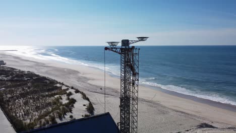 Aerial-view-of-parking-cars,-dunes-and-sandy-beach-with-blue-ocean-of-Portugal-during-summer-day