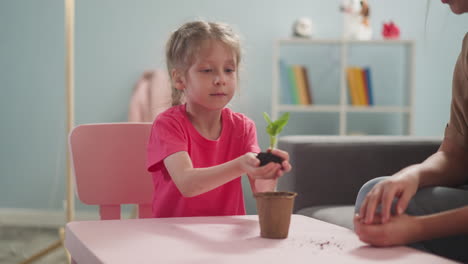 las plantas de la niña brotan flores en casa con su madre