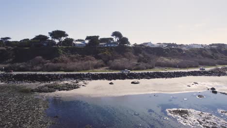 Side-view-following-cars-along-coastal-road-by-beach-of-Bandon-Oregon