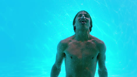 happy man posing underwater in swimming pool