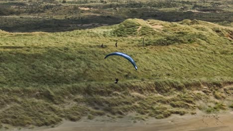 Extremes-Gleitschirmfliegen,-Sonniger-Tag,-Lange-Schatten,-Weite-Luftkamerafahrt-An-Der-Küste,-Strand-Von-Langevelderslag,-Niederlande