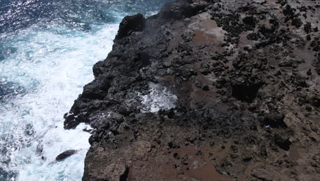 nakalele blowhole, maui, ocean foamy waves crashing on volcanic rocks, aerial