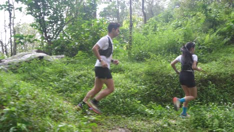 couple trail running in forest