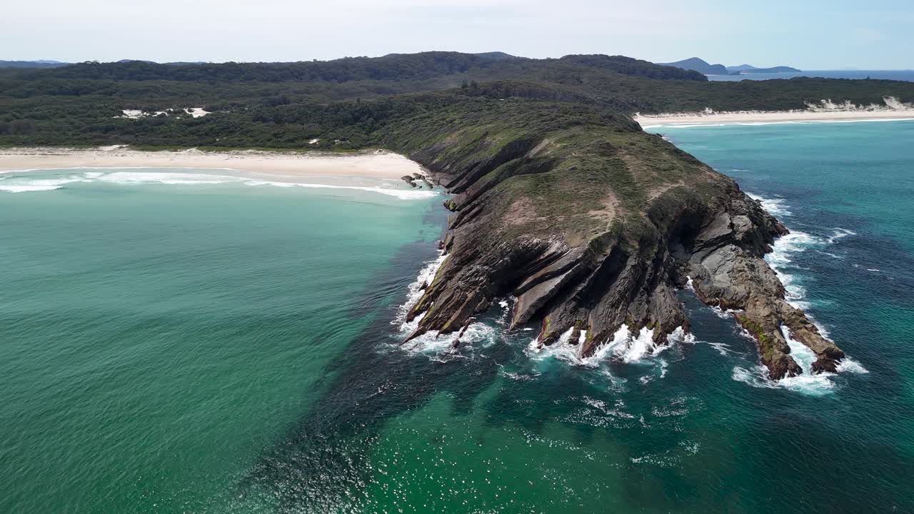 Aerial view of the rocky headland Treachery Head and white sand beaches along the coastline of Seal Rocks Australia
