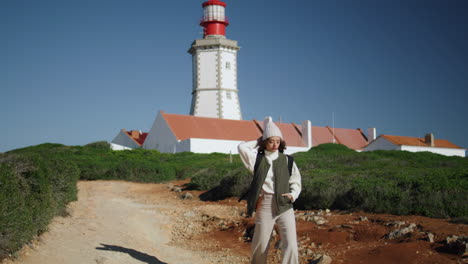 tourist girl walking lighthouse pathway on sunny day. serene woman rest spring