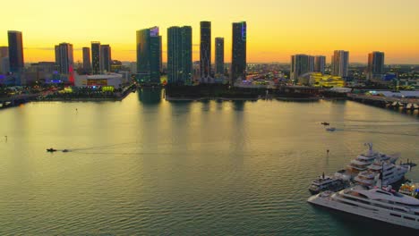 Video-Aéreo-De-Yates-En-Un-Puerto-Deportivo-De-Miami-Florida-Y-El-Horizonte-De-Miami-Durante-La-Puesta-De-Sol,-Suave,-Lujoso-Con-Vista-Panorámica