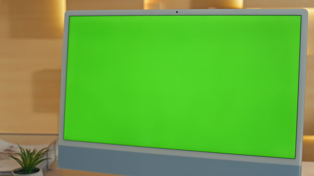 Woman looking at a green screen computer monitor in an office setting