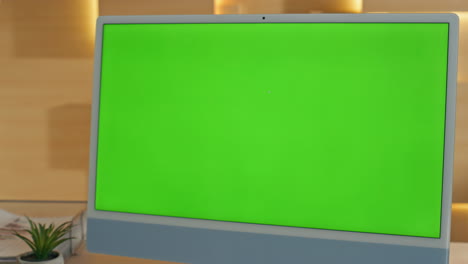 woman looking at a green screen computer monitor in an office setting