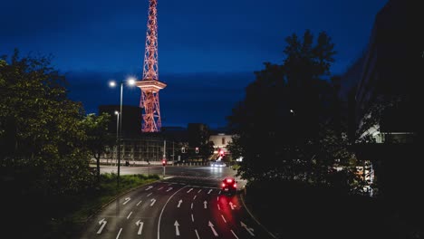 timelapse of cars passing road crossing near funkturm berlin, germany, sight illuminated in many colors during festival of lights