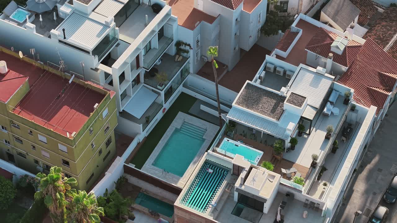 Aerial view of modern homes with swimming pools, sunny and relaxing vibe