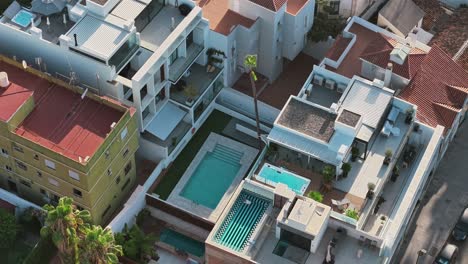 aerial view of modern homes with swimming pools, sunny and relaxing vibe
