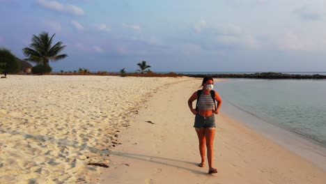 sexy girl with face mask leaving from paradise exotic beach on tropical island after measures from coronavirus outbreak in asian countries