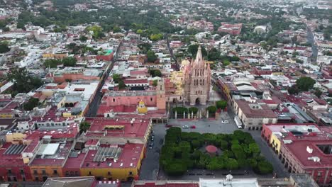 Aerial-shot-over-the-beautiful-colorful-city-of-San-Miguel-De-Allende,-Guanajuato-State-in-Mexico-with-view-of-the-neo-Gothic-church-Parroquia-de-San-Miguel-Arcángel-and-the-colorful-cityscap