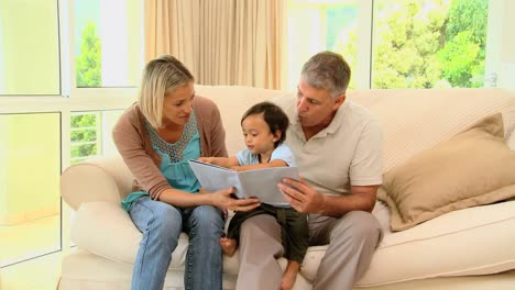 Couple-showing-their-baby-a-childrens-book