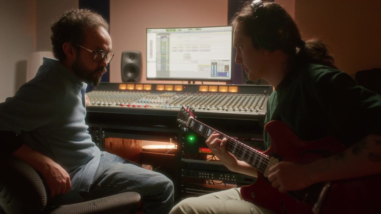 Musician Recording Electric Guitar with Sound Engineer in Professional Studio