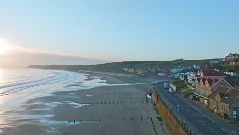 sandsend, whitby, movimiento aéreo de aviones no tripulados de la costa de yorkshire norte a lo largo del frente marítimo hacia atrás